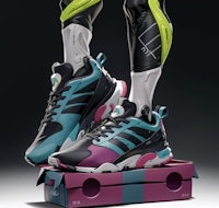 a man standing on top of a box with a pair of sneakers